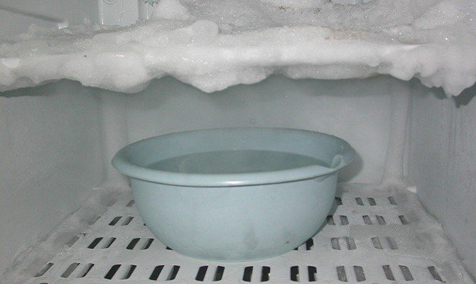 Разморозка холодильника при помощи миски с горячей водой