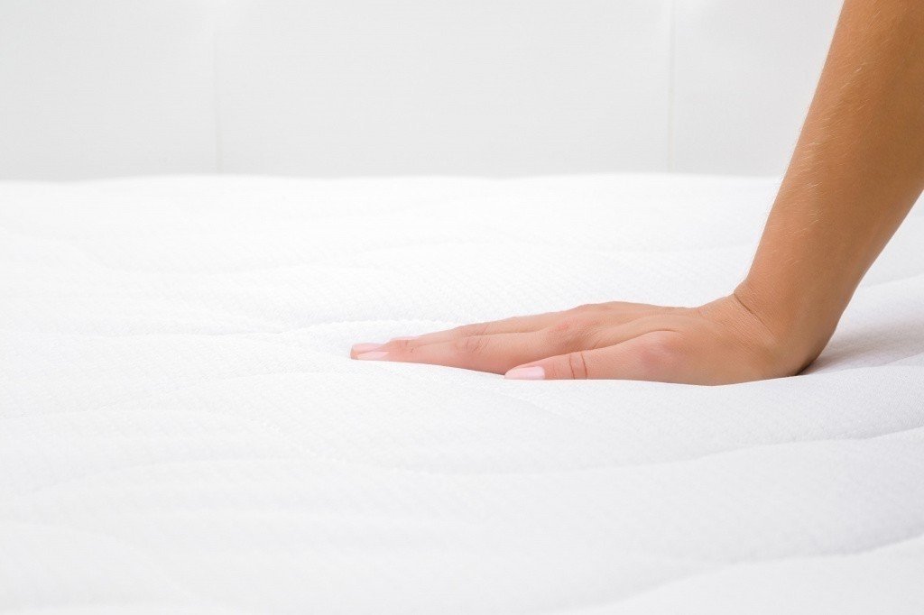 Женская рука нажимает на подушку