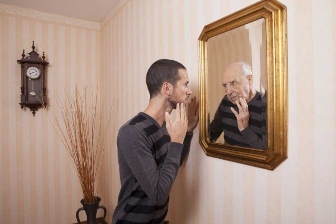 Человек смотрит на себя в зеркало